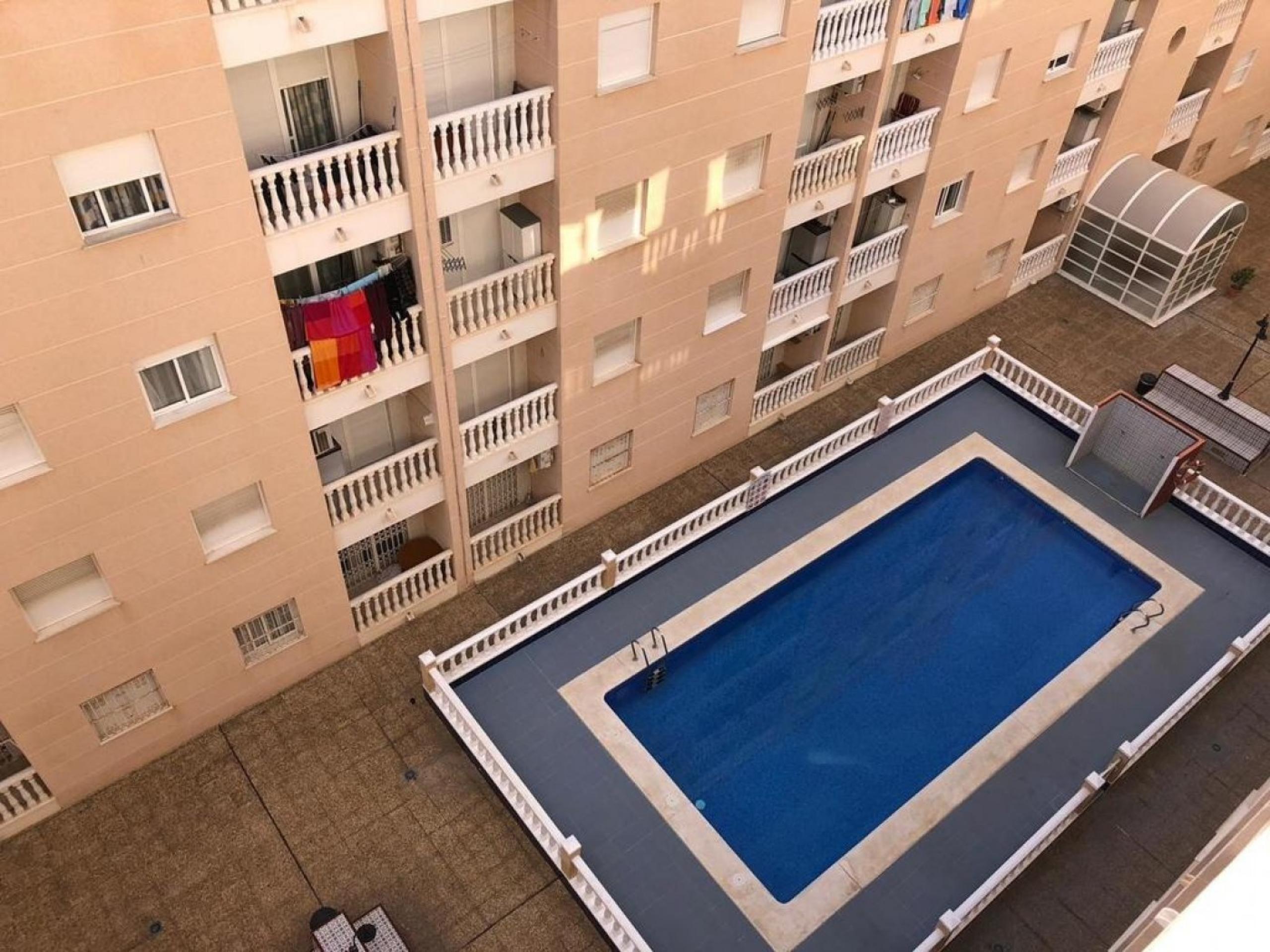 Appartement de 2 chambres avec garage, rangement et piscine commune.